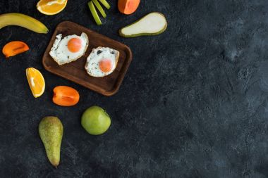 düz lay sahanda yumurta ve meyve karanlık masa üzerinde sağlıklı kahvaltı ile