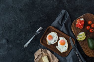 karanlık masa üzerinde sahanda yumurta ve kahvaltı için sağlıklı aperatifler Üstten Görünüm