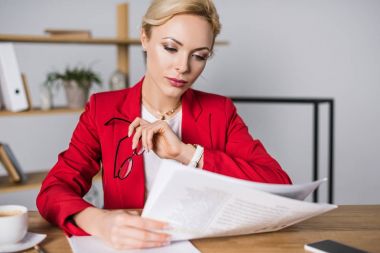 İşyerinde gazete okuma odaklı iş kadını portresi