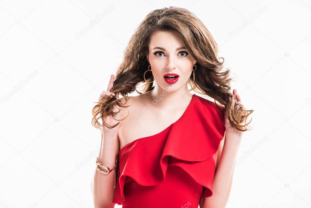 surprised girl in red dress holding hair isolated on white