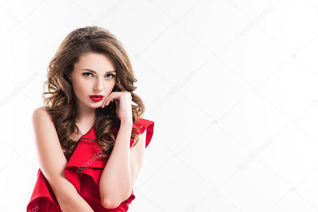 fashionable seductive girl touching face with hand and looking at camera isolated on white