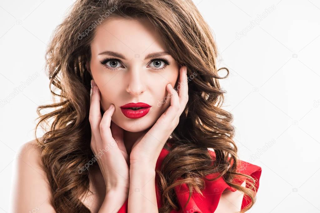 stylish seductive girl touching face with hands and looking at camera isolated on white