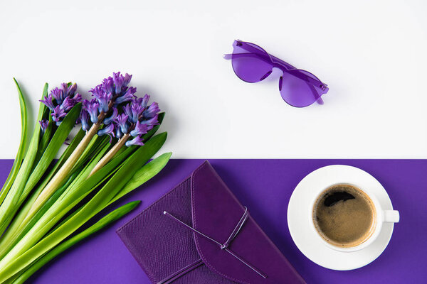 top view of bouquet of purple hyacinth flowers and cup of coffee on table