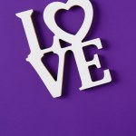 Top view of word love isolated on purple, valentines day concept
