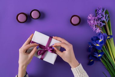 cropped image of girl opening present box on purple clipart