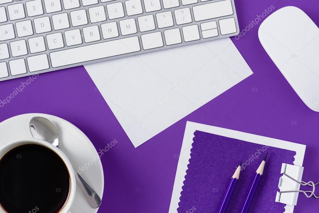 top view of workspace with cup of coffee and computer keyboard