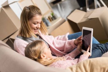 mutlu anne ve kızı eve taşırken ile boş ekran dijital tablet kullanma 