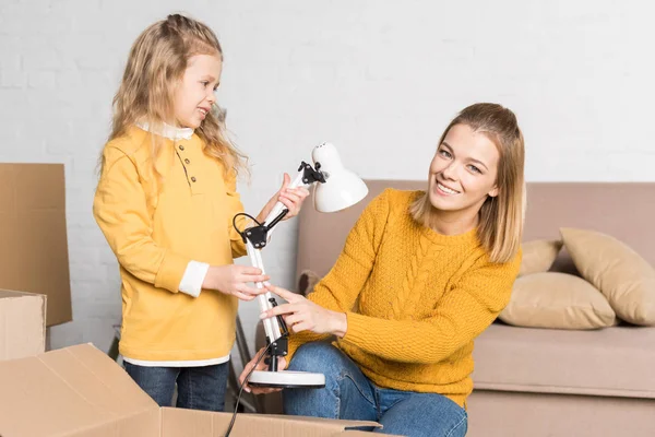 Happy Mother Daughter Holding Lamp While Relocating — Stock Photo, Image