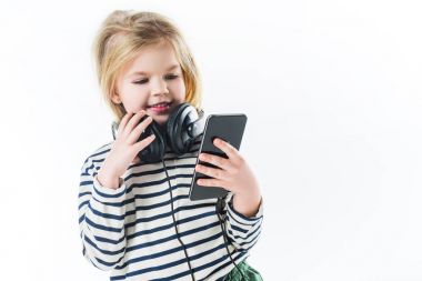 beyaz izole akıllı telefon ve kulaklık ile gülümseyen küçük çocuk