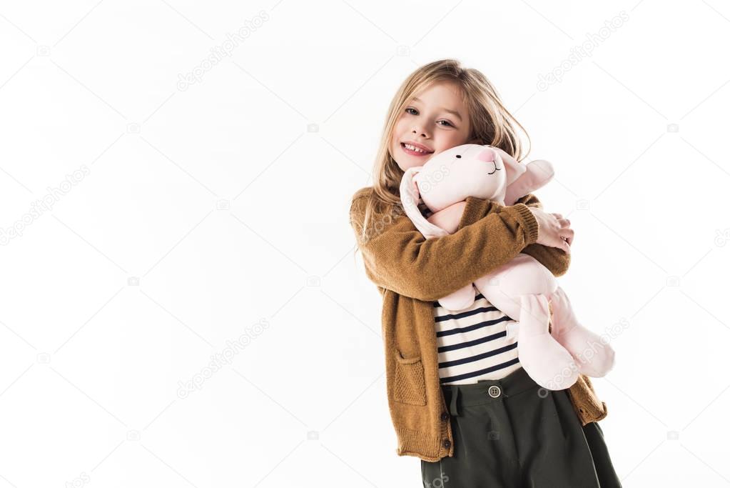 happy little child embracing with soft toy bunny isolated on white