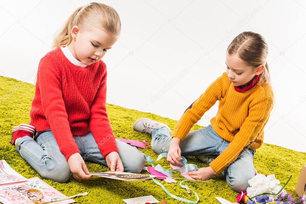 focused little sisters making diy greeting cards isolated on white