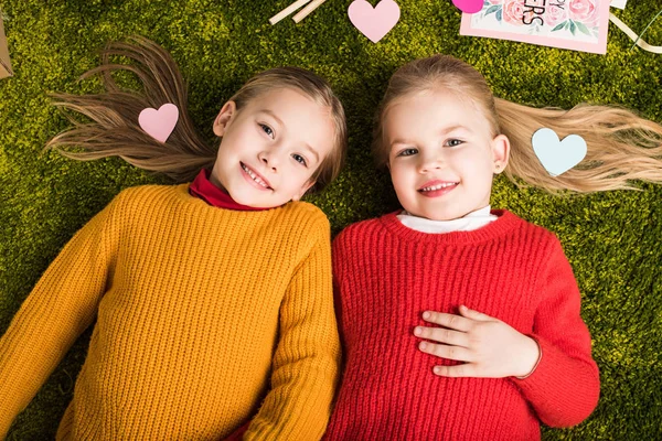 Вид Зверху Щасливі Маленькі Сестри Лежать Килимі Оточенні Сердець — стокове фото