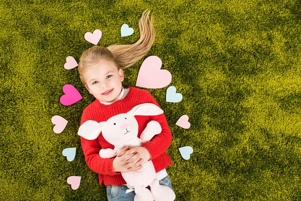 Top View Adorable Little Child Surrounded Hearts Lying Green Soft — Free Stock Photo