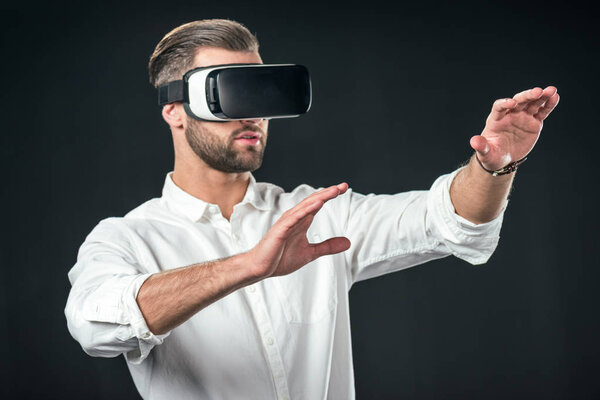 man gesturing and using virtual reality headset, isolated on black