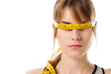 close-up portrait of young woman with measuring tape tied around her eyes isolated on white clipart