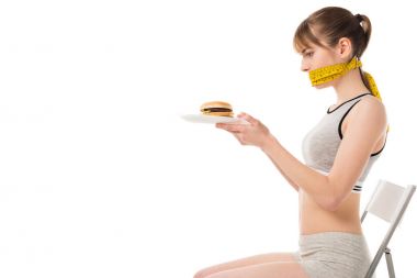 burger üzerine beyaz izole plaka üzerinde tutarak teyp ölçüm ağzı olan genç kadın bağlı
