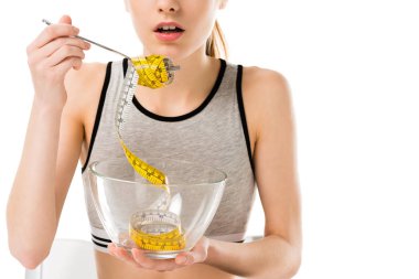 cropped shot of young woman eating mesuring tape isolated on white, anorexia concept clipart