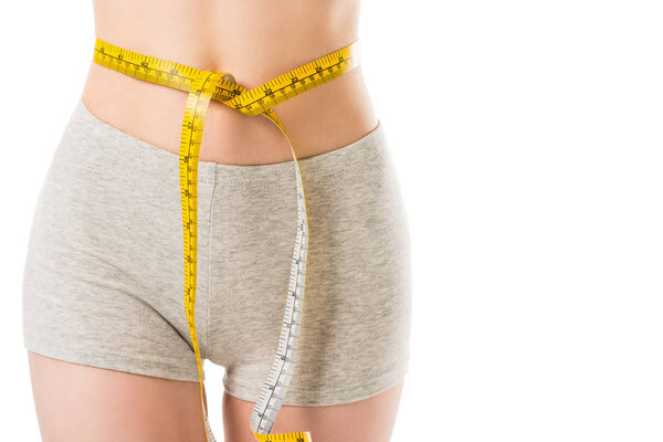 cropped shot of slim woman with measuring tape tied around her waist isolated on white