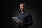 portrét usmívající se muž s digitálním tabletu izolované na černém pozadí