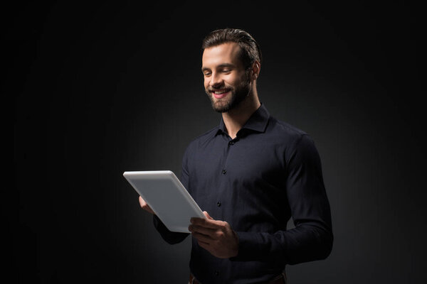портрет улыбающегося мужчины с цифровой табличкой, изолированной на черном

