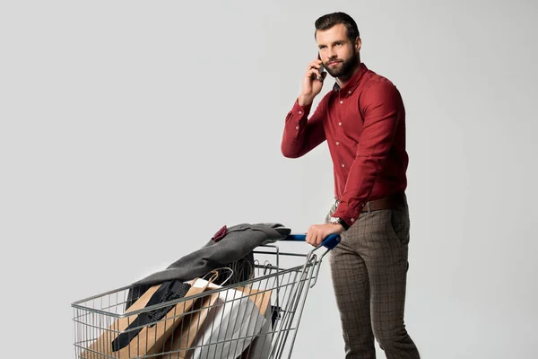 Man Met Winkelwagen Vol Boodschappentassen Jas Praten Smartphone Geïsoleerd Grijs — Stockfoto