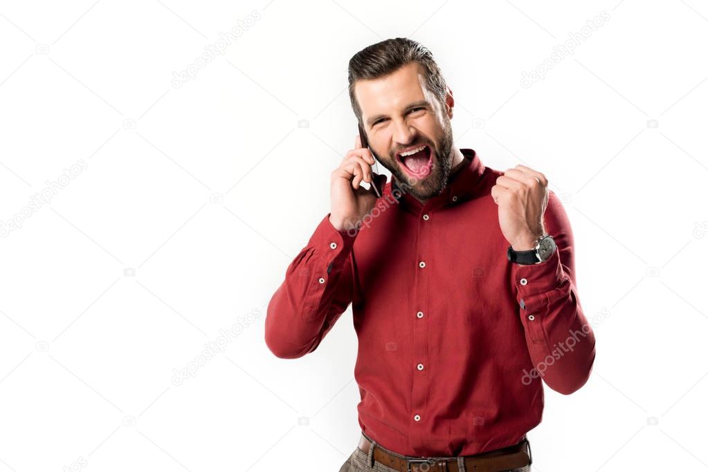 portrait of excited man talking on smartphone isolated on white