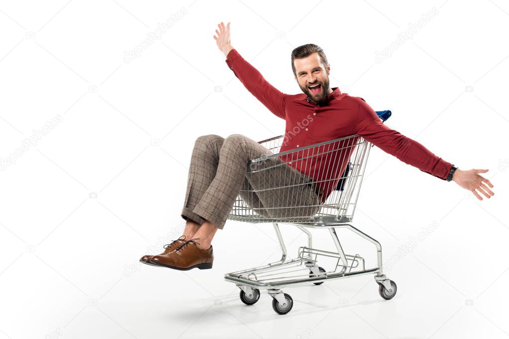 cheerful man sitting in shopping cart isolated on white