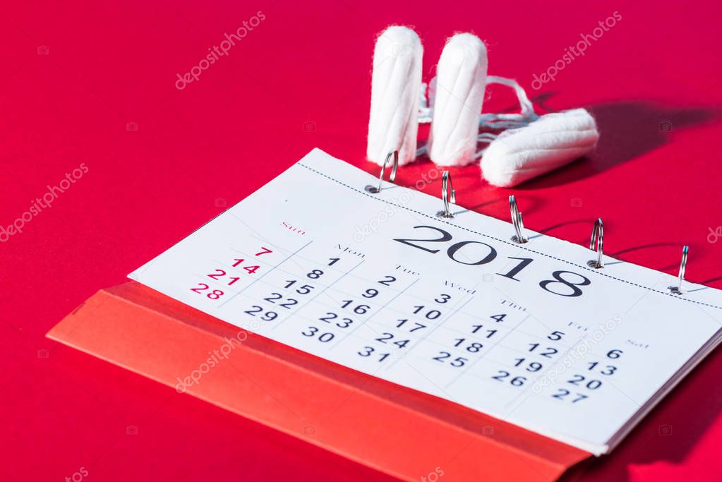 cotton feminine tampons and calendar on red