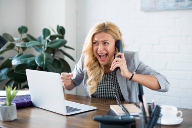 ofiste telefonla konuşurken ve Evet jest gösterilen heyecanlı işkadını