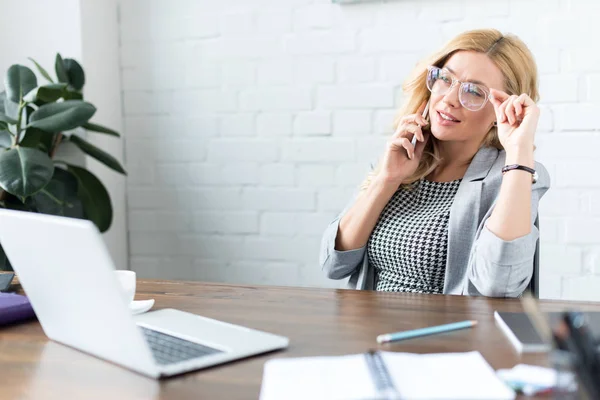 Zakenvrouw Praten Door Smartphone Kantoor Aanraken Van Bril — Gratis stockfoto