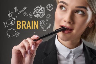 portrait of beautiful young businesswoman with pen and word brain with icons isolated on grey clipart