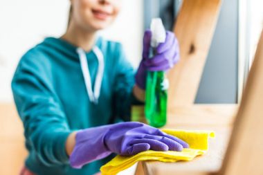 selective focus of woman in rubber gloves cleaning home clipart