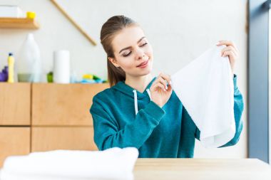 Tablonun üst beyaz havlu tutan genç kadın gülümseyerek