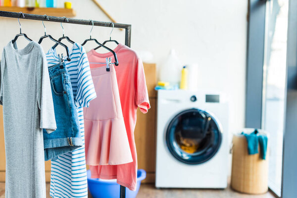 clothes on hangers and washing machine at home