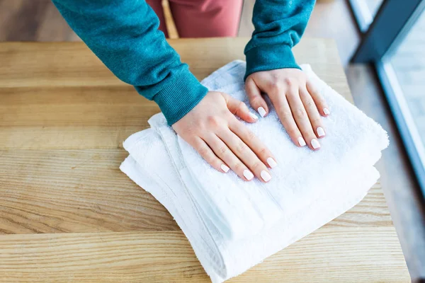 Abgeschnittene Frauenhände Und Saubere Weiße Handtücher Auf Dem Holztisch — Stockfoto