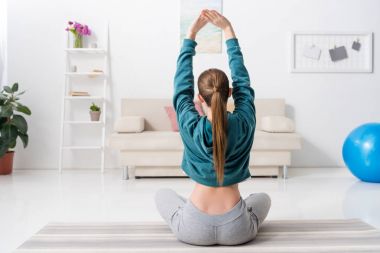 Dikiz lotus pozisyonda oturan ve evde yoga yaparken kız