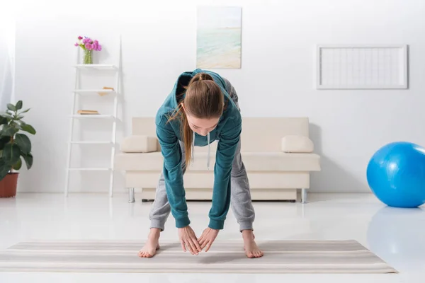 Девушка Осуществляет Циновке Yoga Дома — стоковое фото