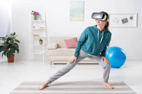 Chica Estirando Piernas Con Auriculares Realidad Virtual Estera Yoga Casa — Foto de Stock