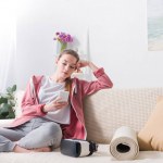 Chica usando el teléfono inteligente en el sofá en casa