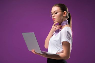 laptop üzerinde mor izole dalgın kız yan görünüm