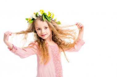 Smiling kid wearing wreath band from flowers and holding her hairs isolated on white clipart