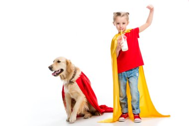 Milkshake içme ve izole üzerinde beyaz yanında kırmızı pelerinli köpek ile el hareketi süper kız