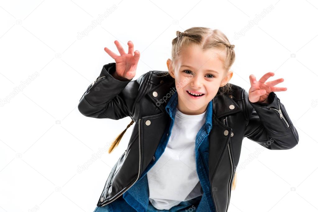 Stylish child with pigtails wearing leather jacket doing scaring gesture isolated on white