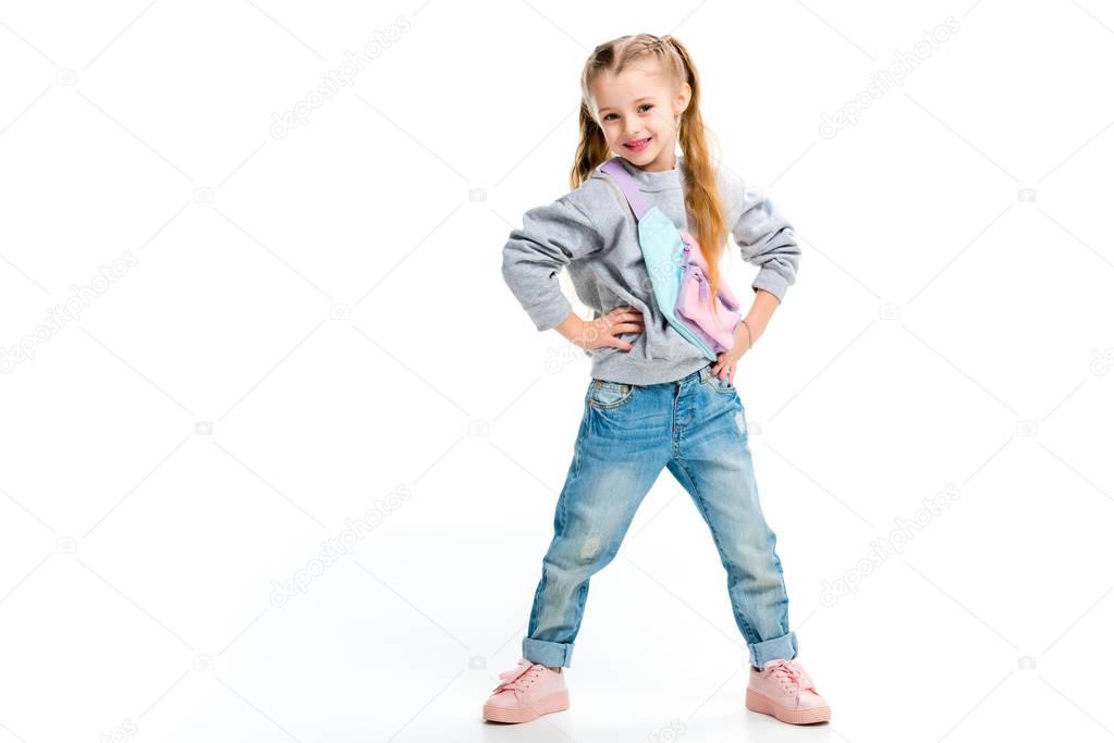 Stylish child standing with arms on thighs isolated on white