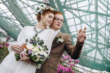 birlikte ayakta ve uzak Botanik bahçesinde arıyorum güzel genç redhead düğün çift düşük açılı görünüş