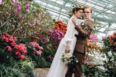 güzel ihale genç Düğün çifti arasında Botanik Bahçesi içinde çiçek buketi duran ile