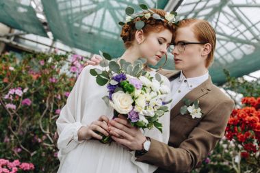 Botanik Bahçesi içinde kucaklayan güzel genç redhead düğün çift düşük açılı görünüş