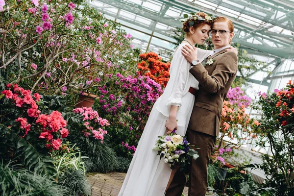 Красива Ніжна Молода Весільна Пара Букетом Стоїть Між Квітами Ботанічному — стокове фото