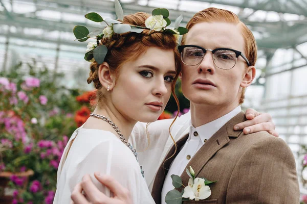 Schönes Elegantes Junges Hochzeitspaar Das Sich Umarmt Und Die Kamera — kostenloses Stockfoto