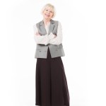 Mujer de negocios mayor sonriente en ropa formal aislada en blanco
